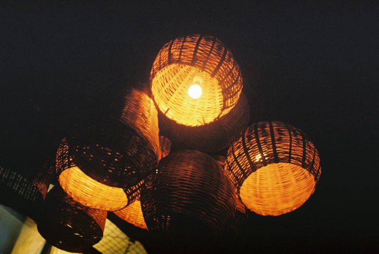 Woven cane lanterns glowing warm against the dark