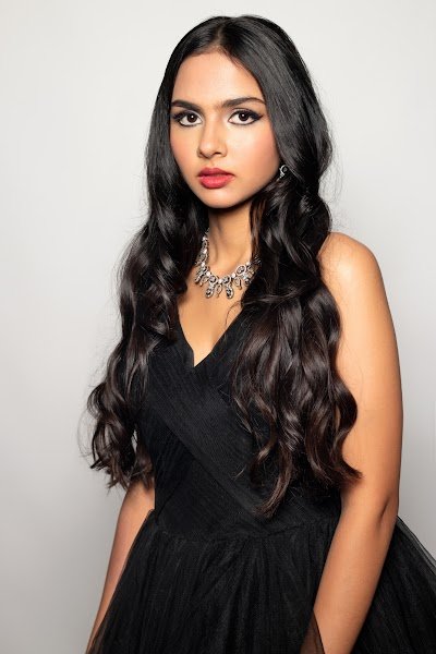 Soft glam makeup: a model in a black gown, long waved hair over one shoulder
