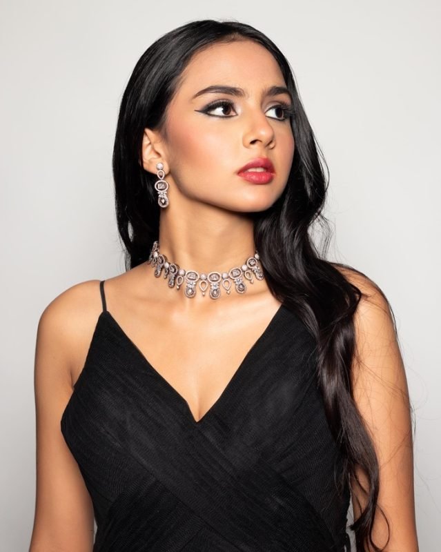 Soft glam makeup: a model in a black gown with a silver necklace and drop earrings