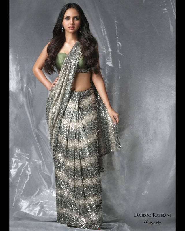 Sargam in a silver sequinned saree with a green blouse against a silver drape