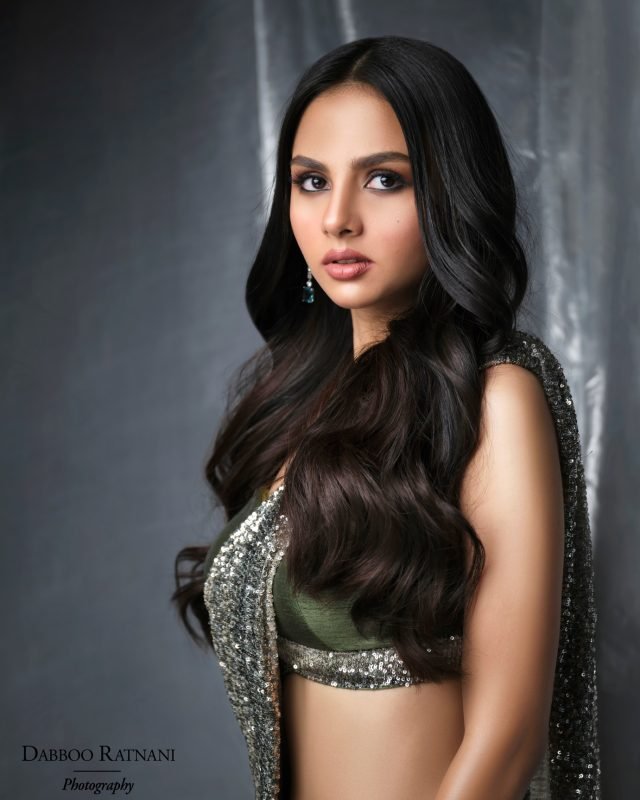 Sargam in a green and silver embroidered blouse and saree against a dark drape