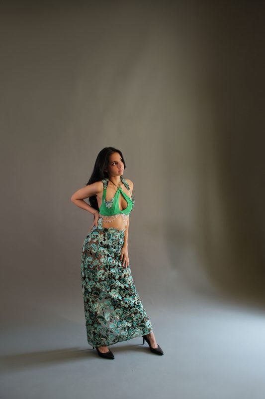 Rea by Rhea lookbook: a model standing in a green halter top and floral maxi skirt